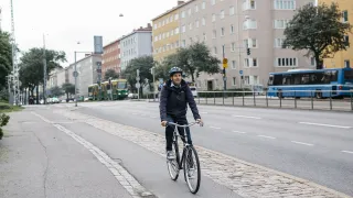 Henkilö pyöräilee kaupungilla.