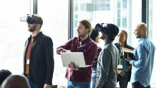 Henkilöitä VR-lasit päässä toimistolla.