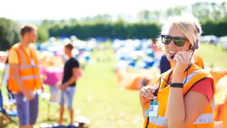Nuori nainen työskentelee festivaaleilla auringonpaisteessa.