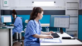 Terveydenhuollon ammattilainen tekee työtään sairaalan toimistossa.