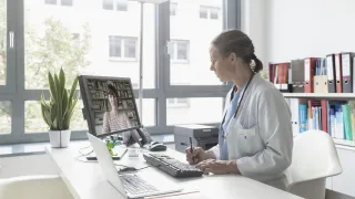 Naislääkäri juttelee asiakkaan kanssa videopuhelun välityksellä