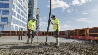 Kaksi rakennusalan työntekiijää tekevät töitä työmaalla
