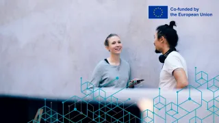 Main image of the AI Actions project: two people having a discussion in an office setting. The project is co-funded by the European Union.