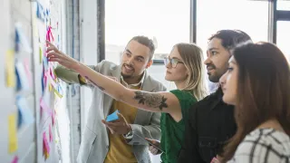 Ryhmä ihmisiä suunnittelee yhdessä.