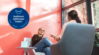 Psykologi keskustelee asiakkaan kanssa vastaanotolla. 