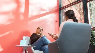 Psykologi keskustelee asiakkaan kanssa vastaanotolla. 