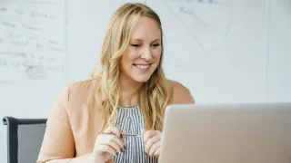 Nainen seuraa tietokoneella verkkotapahtumaa.