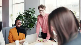 Kolme henkilöä keskustelee toimistotilassa. 