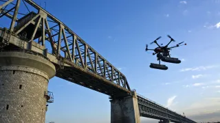 Drooni lentää sillan edessä. 