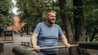 Mies jumppailee puistossa.