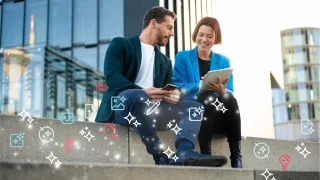 Mies ja nainen istuvat portailla ja katsovat kannettavaa tietokonetta