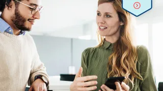 Kollegat keskustelemassa matkapuhelin kädessä