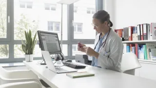 Lääkäri istuu työpöytänsä ääressä