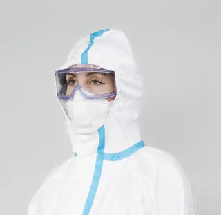 Rintakuva henkilöstä, jolla on yllään FFP3-hengityksensuojain ja naamiomalliset silmiensuojaimet. Käyttö on kuvattu tarkemmin tekstissä.