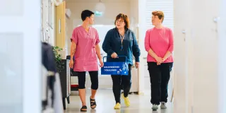 Janna Äijälä (vas.), Katja Saarinen ja Heidi Salminen Attendo Repolasta kävelevät käytävällä.  