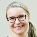 Henkilö katsoo kameraan ja on kuvattavana vaaleaa taustaa vasten.